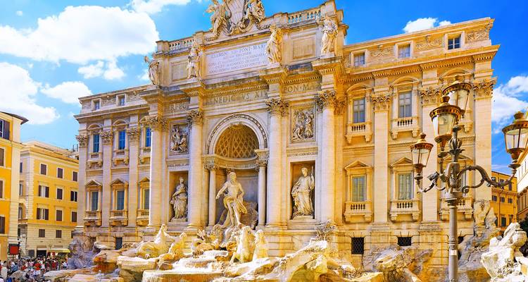 Der Trevi-Brunnen glänzt im hellen Sonnenlicht, während sich Menschenmassen um seine kunstvollen Skulpturen und das kaskadenartig herabfließende Wasser versammeln.
