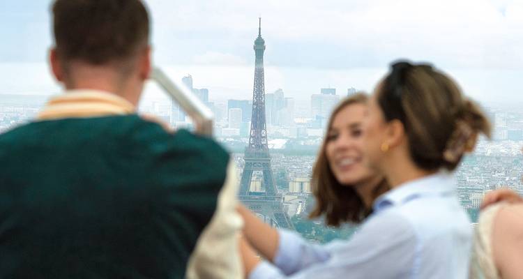 Les voyageurs profitent d'une vue lointaine de la tour Eiffel depuis le sommet d'une plateforme d'observation parisienne