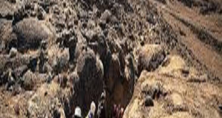 Des randonneurs marchant à travers un terrain rocheux, indiquant une expérience dans la nature.