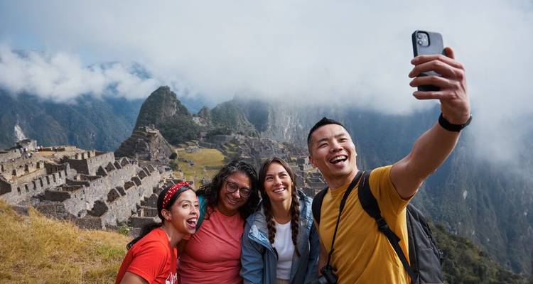 Groupe prenant un selfie avec le Machu Picchu en arrière-plan.