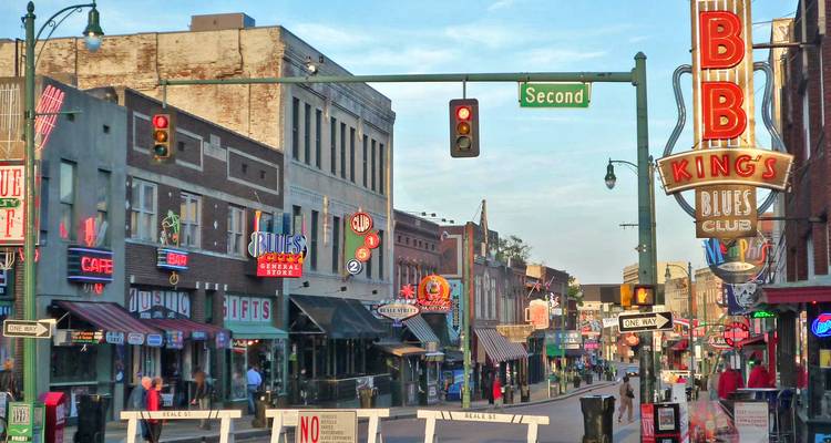 Vue de rue d'un quartier urbain animé avec diverses enseignes et boutiques.