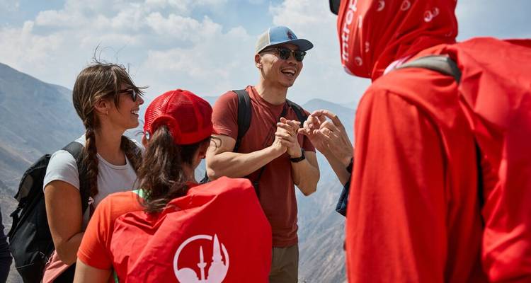 Groupe de personnes qui parlent près d'un sentier de montagne.