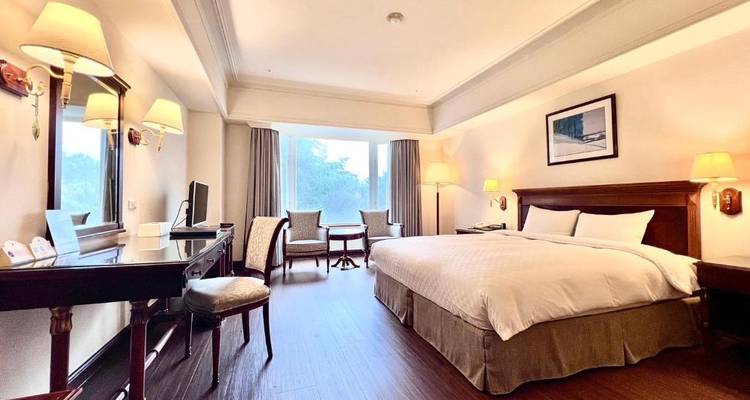 Chambre d'hôtel spacieuse avec un mobilier élégant et de la lumière naturelle.