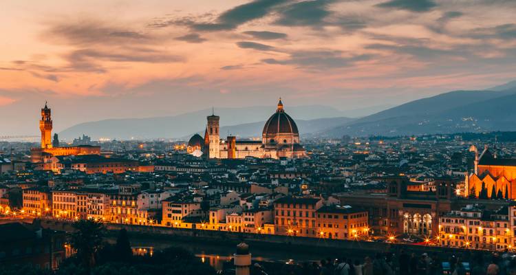 Florence city skyline at sunset with prominent domes and towers.