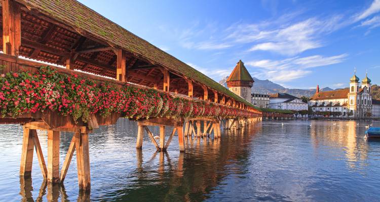 Chapel Bridge with flowers over a river in Lucerne.