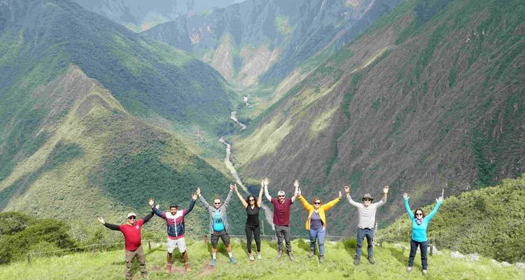 Groep wandelaars met berglandschap op de achtergrond.