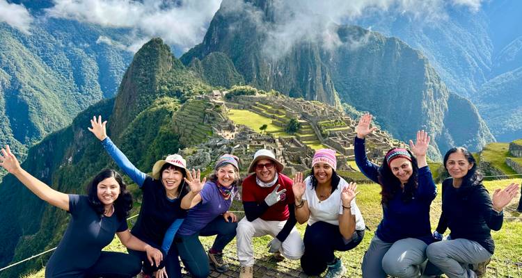 Groep vrouwen die poseren met Machu Picchu op de achtergrond.