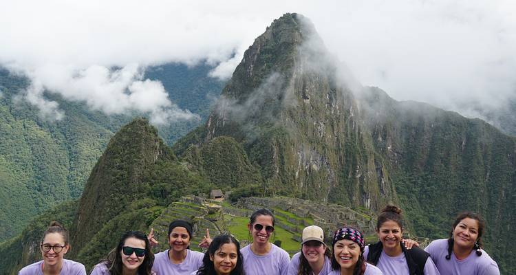 Vrouwen die glimlachen voor Machu Picchu met de berg op de achtergrond.