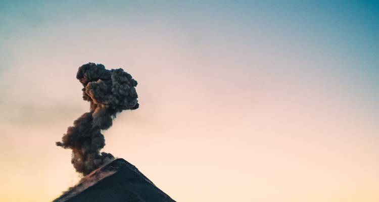 Vulkanische uitbarsting met opkomende rook.