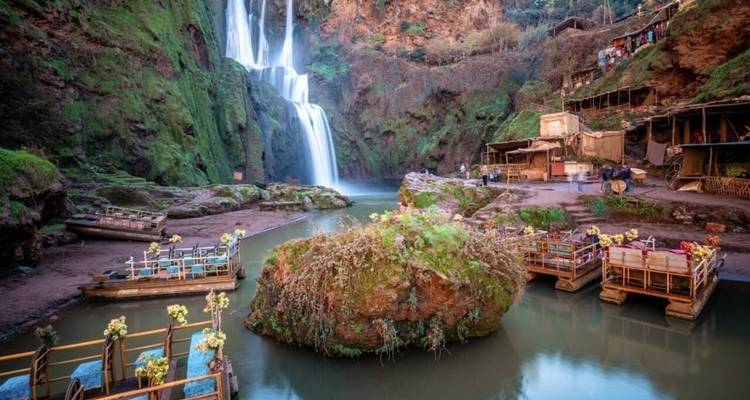 Des bateaux touristiques près de la base d'une cascade.