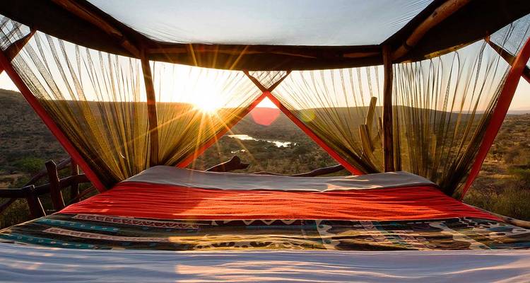 Zonsondergangzicht vanaf een bed met uitzicht op het landschap