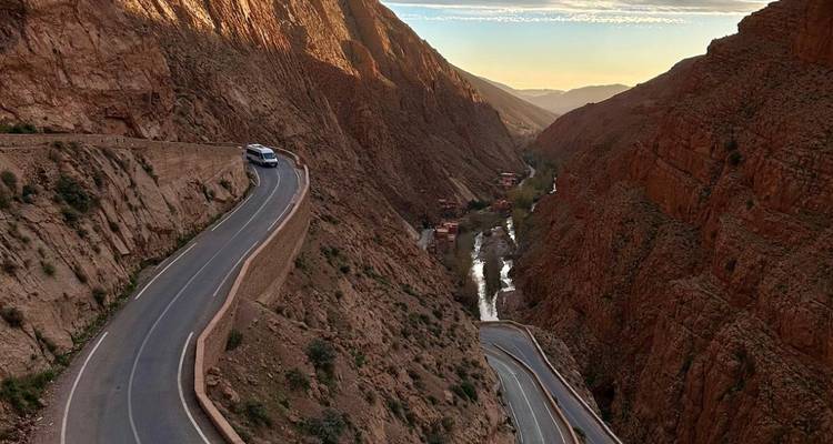 Kurvenreiche Straße durch eine tiefe Schlucht, Auto auf der Straße sichtbar.
