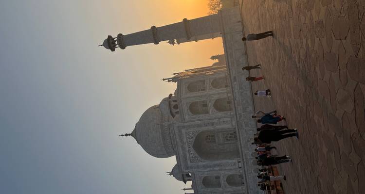 Gesilhouetteerde bezoekers bewonderen de Taj Mahal tijdens de warme gloed van de zonsondergang.