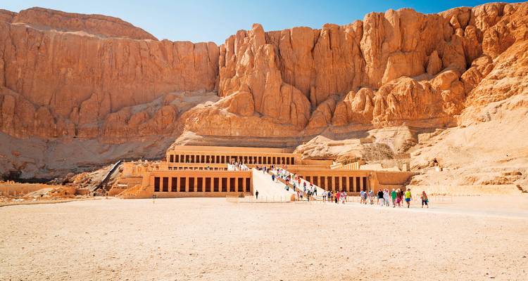 Temple d'Hatchepsout avec des touristes en visite, situé dans un paysage désertique.