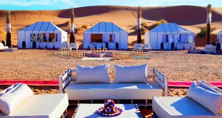 Woestijntenten met luxueuze zitarrangementen en woestijnachtergrond.