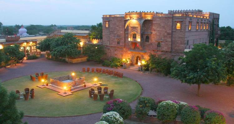 Historisch gebouw omgeven door tuinen en zithoek.