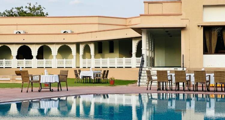Una zona exterior con piscina y mesas.