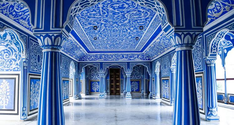 Una habitación azul intrincadamente pintada con columnas y arcos.