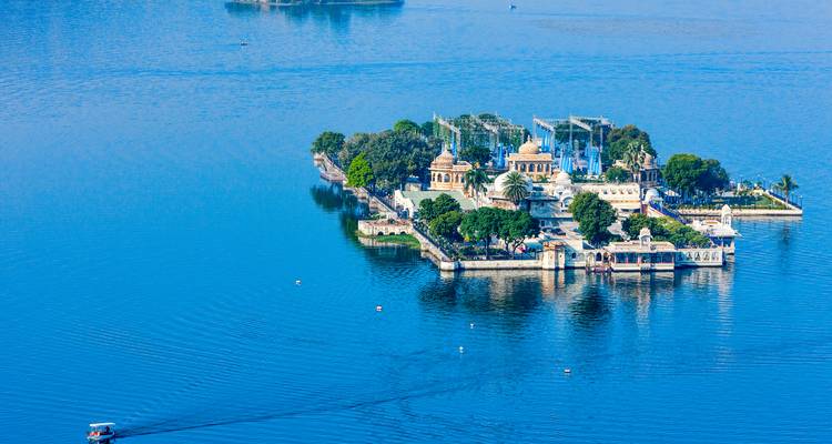 Una isla en un lago con exuberante vegetación y arquitectura.