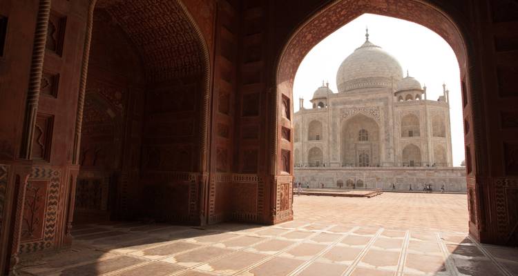Taj Mahal betrachtet durch einen Torbogen mit kunstvollen Verzierungen
