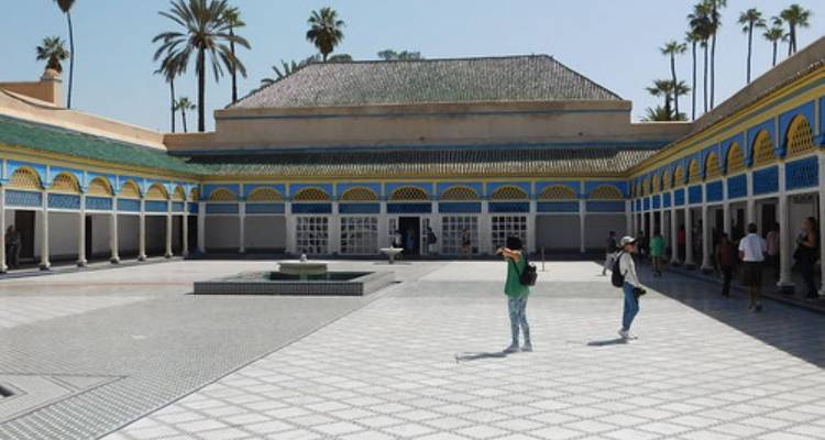 Interior courtyard of a traditional building with arches and palm trees.