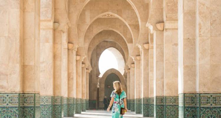 Personne marchant dans un couloir d'architecture marocaine.