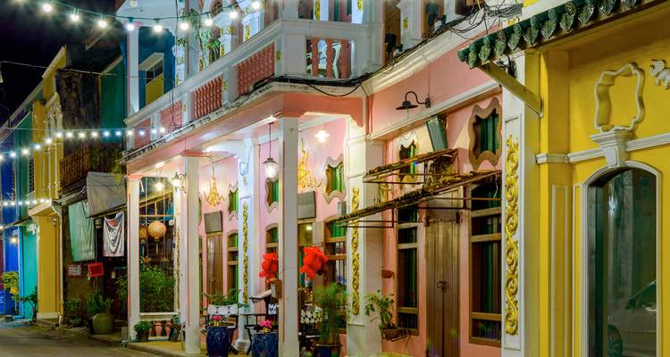 Colorful, historic street with string lights at dusk.