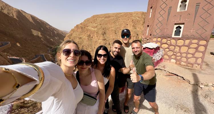 Grupo de amigos tomándose una selfie con una escena del desierto de fondo.