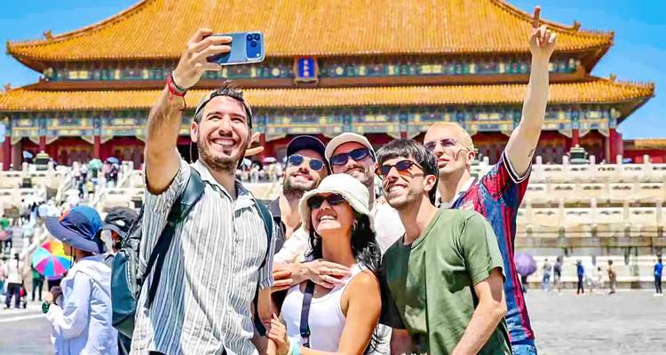 Glimlachende reizigers die een selfie nemen voor de Poort van Hoogste Harmonie van de Verboden Stad op een zonnige dag.