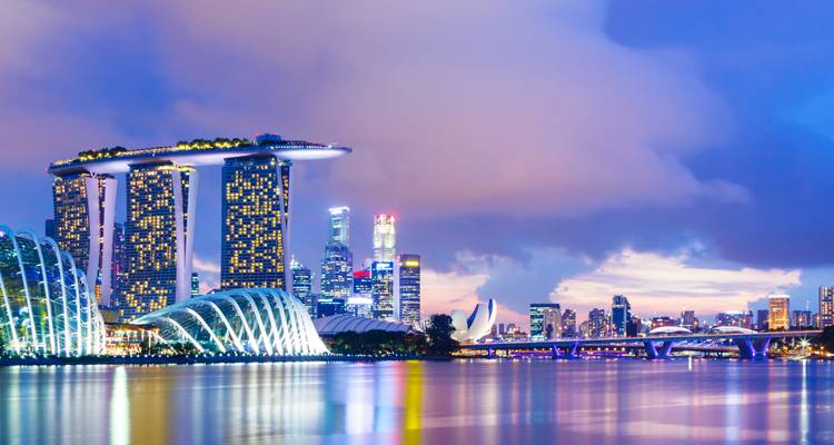 Skyline van een stad met een futuristisch gebouw en waterkant.