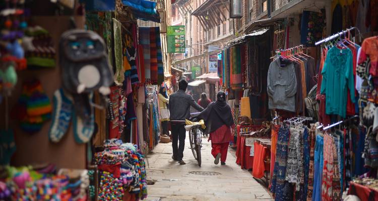 Enge lebendige Marktstraße voller Menschen.