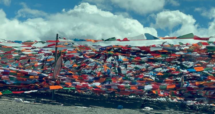 Coloridas banderas de oración ondeando bajo un cielo despejado.
