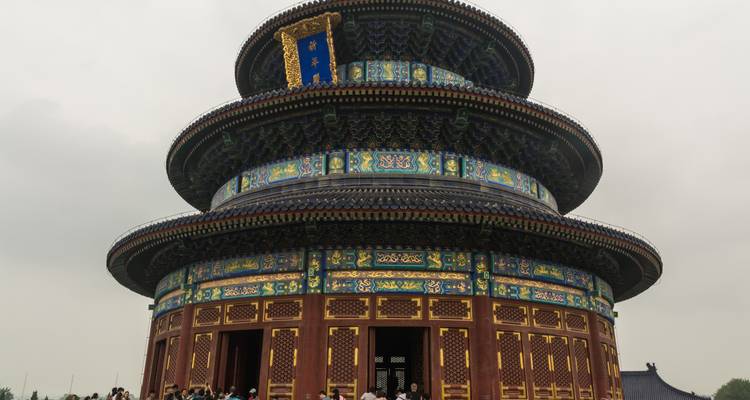 El Templo del Cielo y su Salón de la Plegaria con visitantes reunidos en su base en un día nublado.