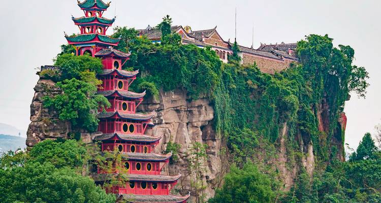 Een traditionele Chinese pagode op een rotsachtige heuveltop.