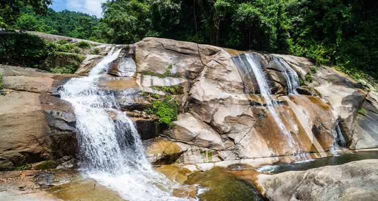 Cascade sur des formations rocheuses dans un environnement serein.