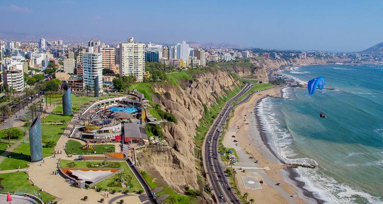 Una ciudad costera con edificios altos a lo largo de un acantilado y una playa.