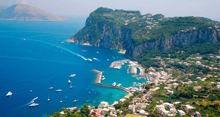 Luftaufnahme der Insel Capri mit einem Hafen und türkisfarbenem Wasser.