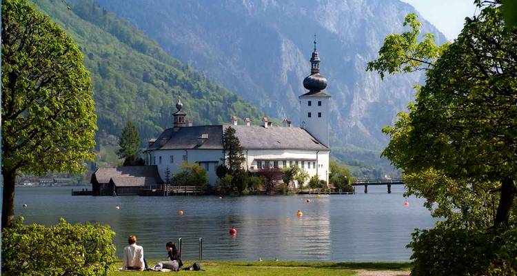 Lakeside building with mountains in the background.