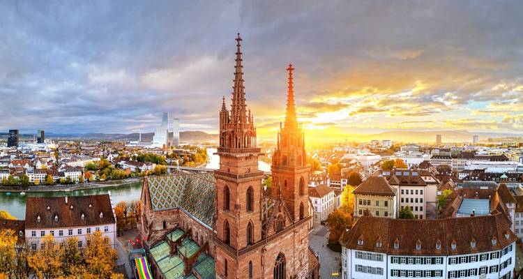 Sonnenuntergang über einer Stadt mit einer historischen Kathedrale und einem Fluss.