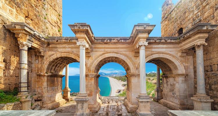 Arched stone structure overlooking a beach.