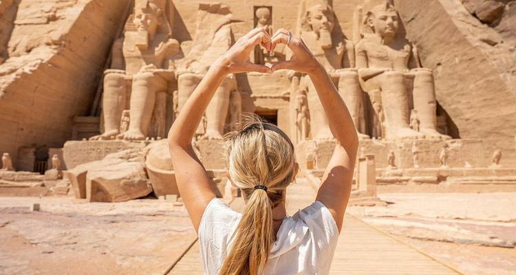 Touriste faisant une forme de cœur avec les mains devant Abu Simbel.