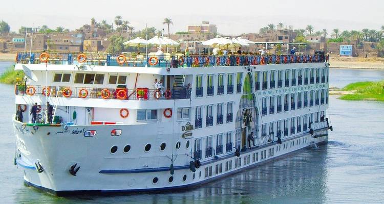 Grand navire de croisière sur une rivière avec une ville en arrière-plan