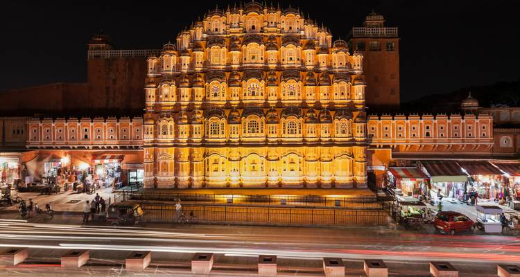 Hawa Mahal nachts beleuchtet mit regem Straßentreiben.