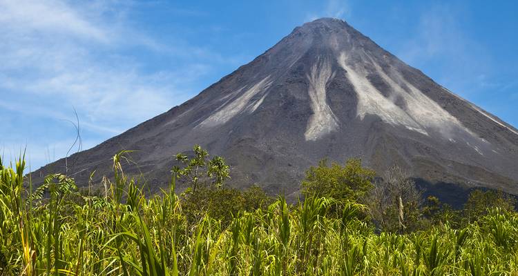 Majestuoso volcán Arenal contra un cielo azul claro.
