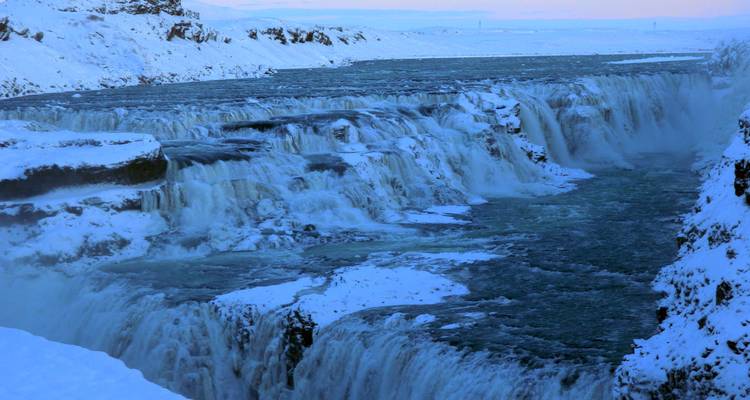 Sneeuwbedekte waterval in een winterlandschap.