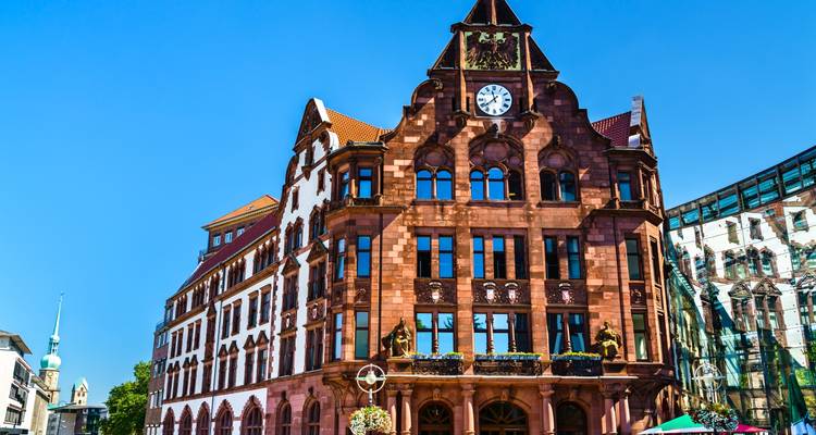 Edificio histórico de ladrillo rojo con una torre de reloj en el centro de la ciudad.