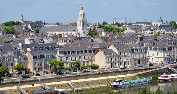 Paysage urbain avec des bâtiments historiques et une vue sur la rivière.
