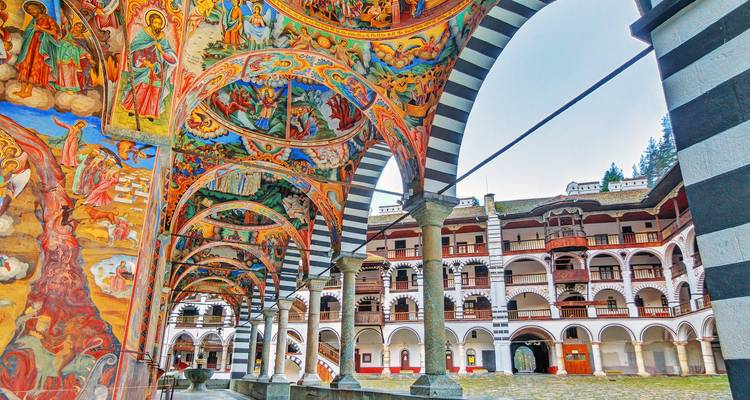 Intricate religious frescoes under Asian architecture.