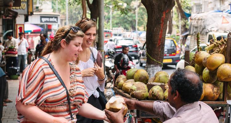 Toeristen die kokosnoten kopen van een straatverkoper.