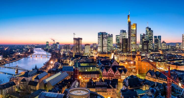 Vue panoramique crépusculaire de l'horizon moderne de Francfort et du fleuve Main reflétant les lumières de la ville.